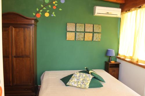 - une chambre avec un lit et un mur vert dans l'établissement Terra di Carini, à Carini