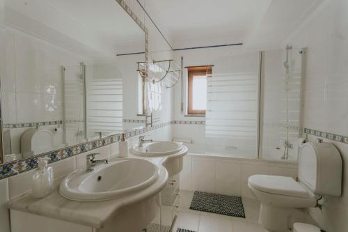 a white bathroom with two sinks and a toilet at Best Houses 53 - The Daisy Moon House in Serra de El-Rei
