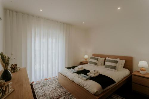 a bedroom with a large bed and a large window at Best Houses 53 - The Daisy Moon House in Serra de El-Rei
