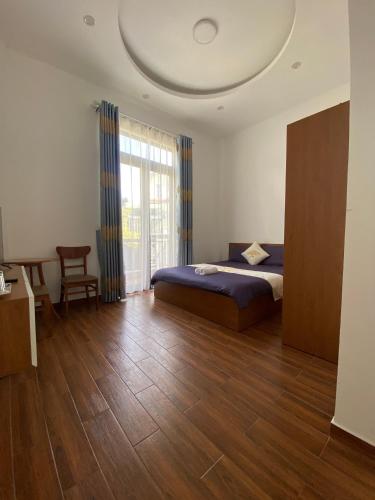 a bedroom with a bed and a large window at Marguerite Villa in Da Lat