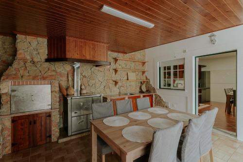 a kitchen and dining room with a wooden table at Best Houses 53 - The Daisy Moon House in Serra de El-Rei