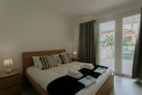 a bedroom with a bed and a large window at Best Houses 53 - The Daisy Moon House in Serra de El-Rei