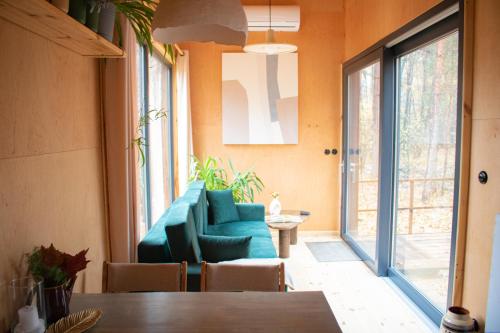 una sala de estar con un sofá y una mesa en Carthome - wyjątkowe miejsce leśnego wypoczynku, en Zynie
