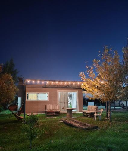 a house with lights on it in a yard at Chacra LANATIVA in Poblado Echeverry