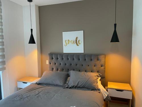 a bedroom with a bed and two night stands at Astoria Apartments in Bogotá