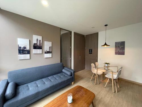 a living room with a blue couch and a table at Astoria Apartments in Bogotá
