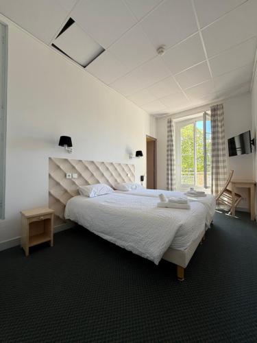 une chambre blanche avec un grand lit et une fenêtre dans l'établissement HOTEL ST SEBASTIEN, à Roquebillière