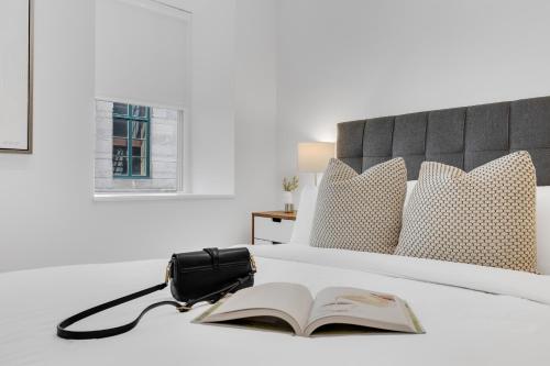a bed with a book and a bag on it at The SFX Old Port in Montréal