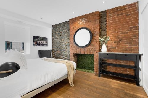 a bedroom with a brick wall and a bed and a mirror at The SFX Old Port in Montréal