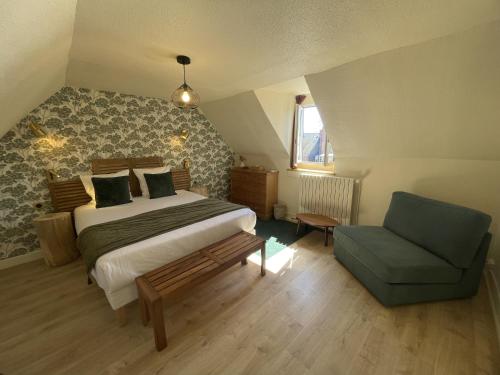 a bedroom with a bed and a blue chair at Le Trouville - Hôtel de Charme in Trouville-sur-Mer