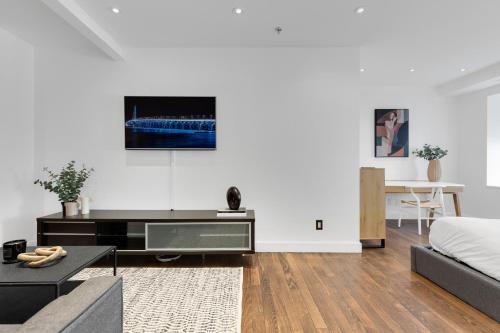 a living room with a couch and a tv on a wall at The SFX Old Port in Montréal