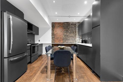 a kitchen with black cabinets and a table with chairs at The SFX Old Port in Montréal