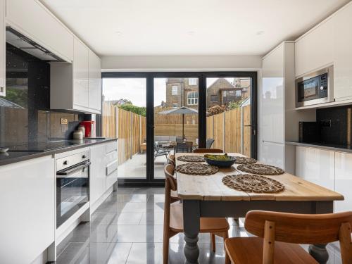 a kitchen with a wooden table with chairs and a table at Stylish 5BR Home in the Heart of Spitalfields Walk to Brick Lane & Shoreditch in London