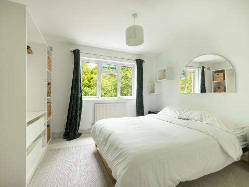 a white bedroom with a large bed and a window at Stylish 5BR Home in the Heart of Spitalfields Walk to Brick Lane & Shoreditch in London