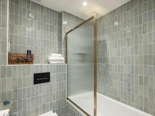 a shower with a glass door in a bathroom at Stylish 5BR Home in the Heart of Spitalfields Walk to Brick Lane & Shoreditch in London