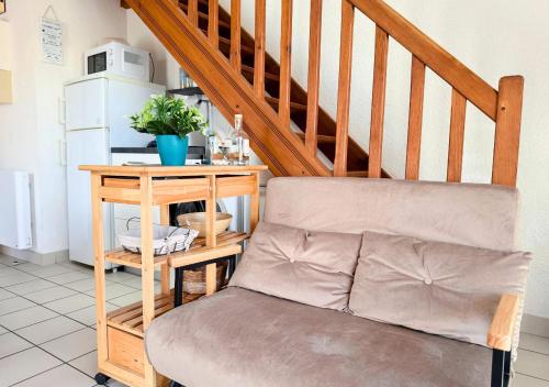 un salon avec un canapé et un escalier dans l'établissement Duplex la Baleine Bleue, à Biscarrosse