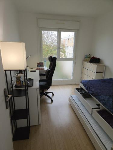 - une chambre avec un bureau, un lit et une chaise dans l'établissement Chambres à 15 mn du centre et 10 mn des 24H par le Tram, au Mans