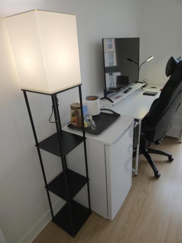 un bureau avec un bureau et une lampe. dans l'établissement Chambres à 15 mn du centre et 10 mn des 24H par le Tram, au Mans