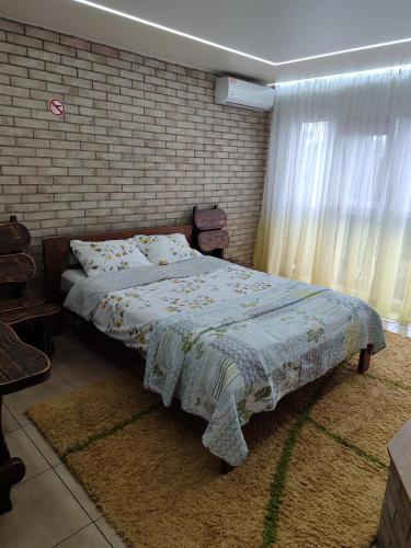 a bedroom with a bed and a brick wall at Дачний будинок in Kobelyaky