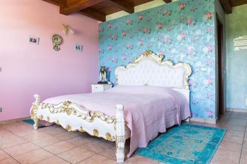 a bedroom with a white bed with floral wallpaper at Villa "Piemonte" in Tigliole