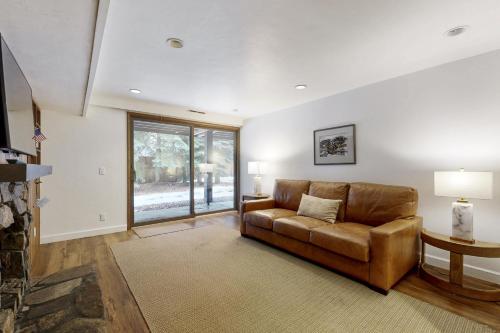 a living room with a brown couch and a window at Sun Valley Alpenglow in Ketchum