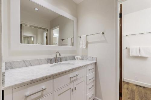 a white bathroom with a sink and a mirror at Sun Valley Alpenglow in Ketchum