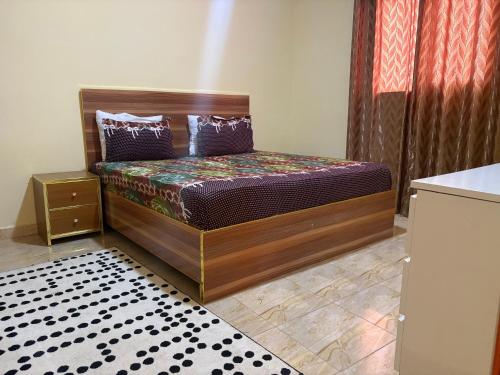 a bedroom with a bed with a wooden headboard at Ouest foire in Dakan