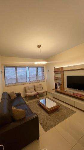 a living room with a couch and a flat screen tv at Lindo apartamento 50 metros da praia in Cabedelo