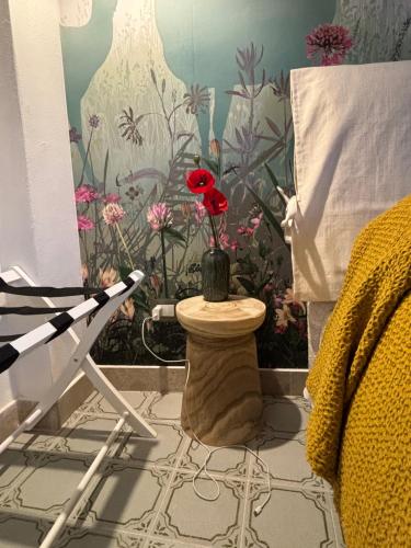 a room with a table with a vase with a flower on it at Casa Calogera - Romantica Dimora a Cammarata in Cammarata