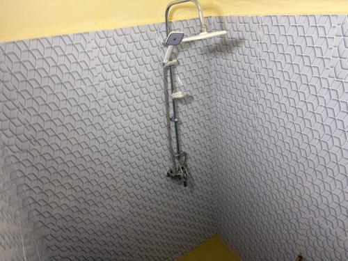 a shower in a bathroom with a gray wall at Ouest foire in Dakan