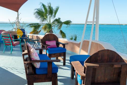 a group of chairs and tables next to the ocean at Casa Kootenay Waterfront Bnb in La Paz