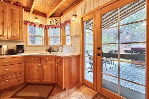 a kitchen with wooden cabinets and a large window at Quiet Canyon Starry Nights HappyOurs Ranch Bunk Family Home in Glendale
