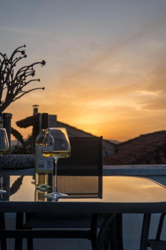 a table with wine glasses on it with a sunset at Acropolis 360 Residence,2 bedr in Athens