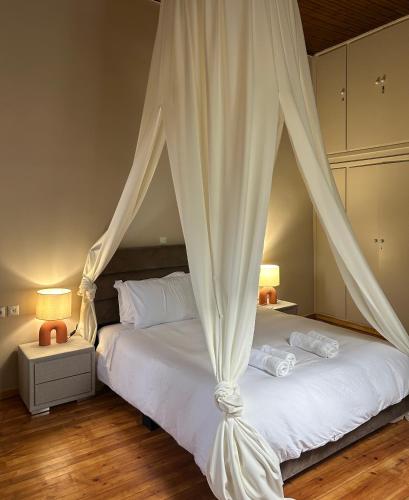 a bedroom with a white bed with a canopy at Acropolis 360 Residence,2 bedr in Athens