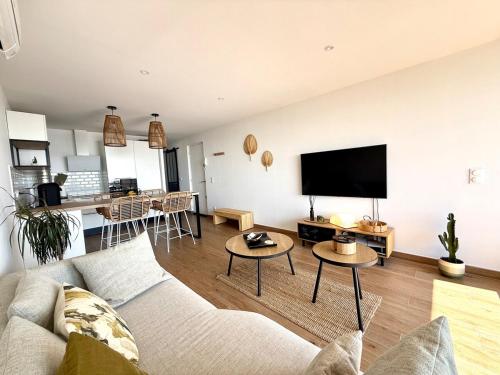 un salon avec un canapé et une télévision à écran plat dans l'établissement Appt bord de mer,Clim & parking, à La Grande Motte