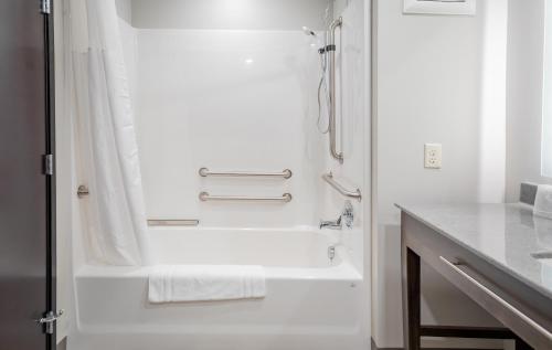 a white bathroom with a shower and a tub at My Place Hotel-Raleigh Garner, NC in Garner
