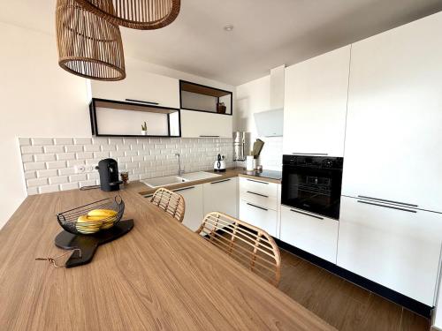 - une cuisine avec une table en bois et un bol de bananes dans l'établissement Appt bord de mer,Clim & parking, à La Grande Motte
