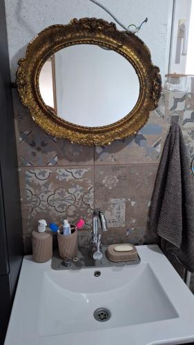 a bathroom sink with a gold mirror above it at Maki Village in Bukorovac