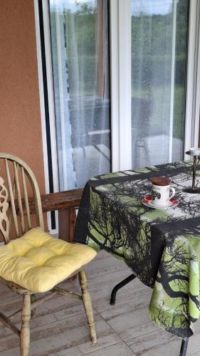 a table and a chair with a table and a cup on it at Maki Village in Bukorovac