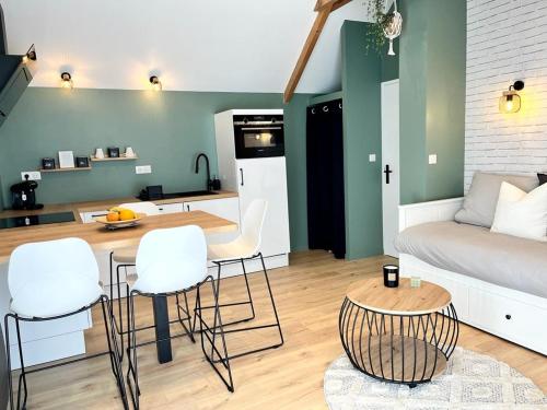a living room with a couch and a table and chairs at Le 5, loc studio malouin in Saint Malo