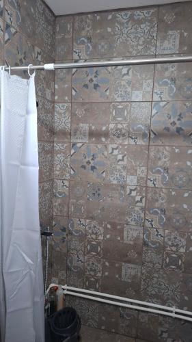 a bathroom with a tiled wall with a towel at Maki Village in Bukorovac