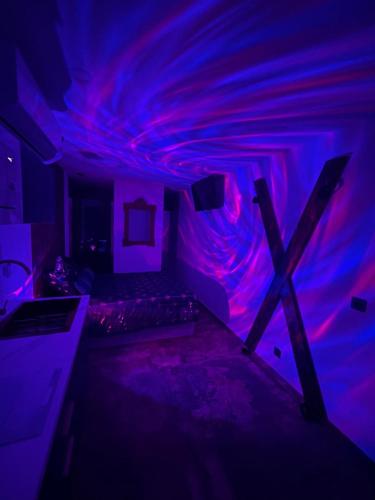 a room with a blue and purple ceiling at La suite des charmes - village naturiste - port nature 2 coursives in Cap d'Agde