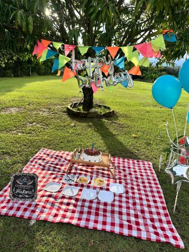 a picnic table with a cake on a picnic blanket at Finca Hotel Villa el Ocaso Huila in Rivera