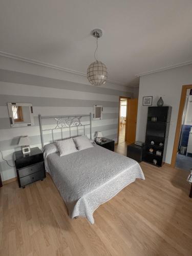 a bedroom with a bed with a white bedspread at Casa Idalia in Ourense