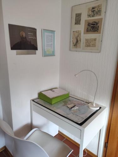 a white desk with a lamp and a chair at Ferienwohnung Annabelle in Hechingen