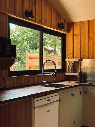 une cuisine avec un évier et une fenêtre dans l'établissement Cabin, terrace and enclosed garden, à Lanton