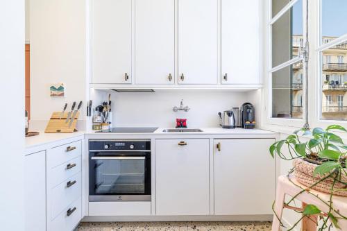 - une cuisine blanche avec des placards blancs et une cuisinière dans l'établissement DOUANE - 2 bedroom in Front of the Port, à Nice