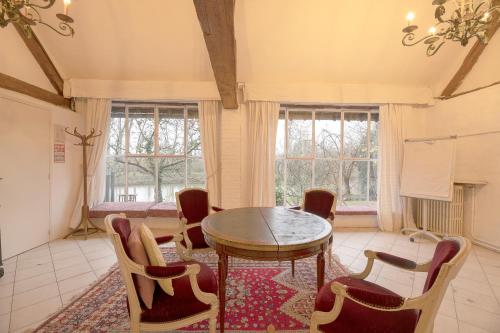Le Moulin d'Andé في Andé: غرفة طعام بها طاولة وكراسي