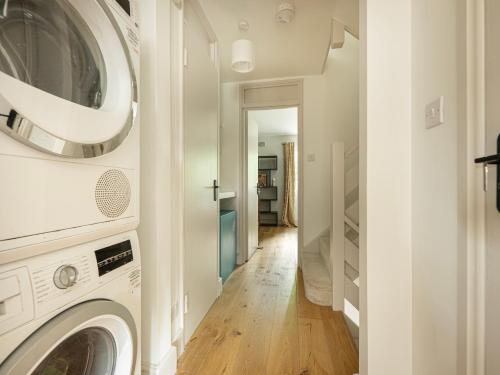 a laundry room with a washer and dryer at Stylish 5BR Home in the Heart of Spitalfields Walk to Brick Lane & Shoreditch in London