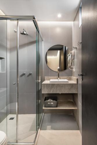 Un baño con lavabo y ducha de cristal. en Pousada Recife, en Recife